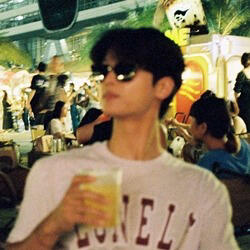 a blurry photo of cha hakyeon in a white shirt, black sunglasses, with a yellow beverage in his hands